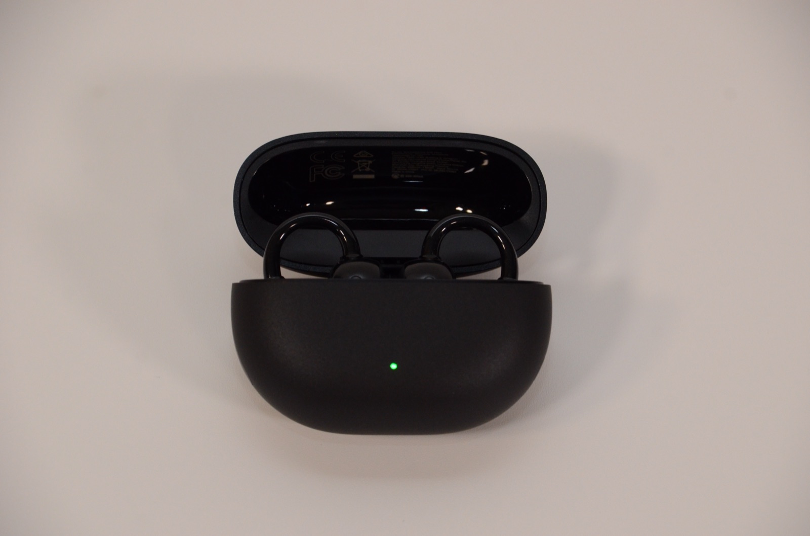 SOUNDPEATS UU2イヤーカフの充電ケースを開けた状態。イヤホン収納中でLEDが点灯