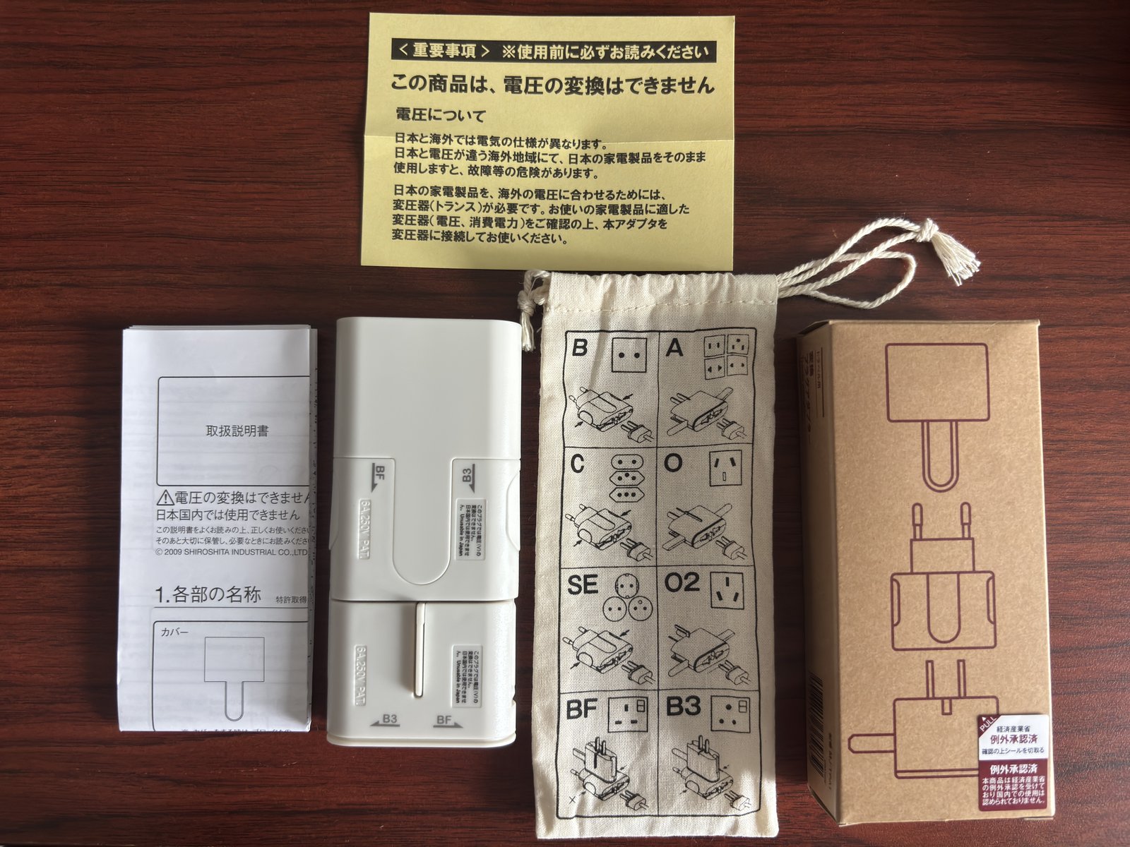 無印の変換プラグの同梱物。金色の注意書きに「この商品は、電圧の変換はできません」とある